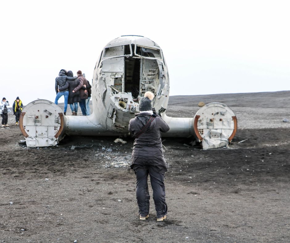 Picture of Jeannie Wearing Layers and taking Pictures of the Sólheimasandur Plane Crash in Iceland | Iceland with a View