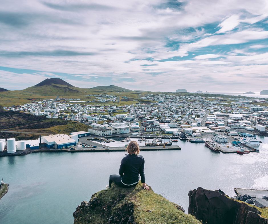 Picture of Jeannie at the Edge of a Cliff Admiring the Breathtaking View of Iceland's Hidden Gem, Westman Islands | Iceland with a View 