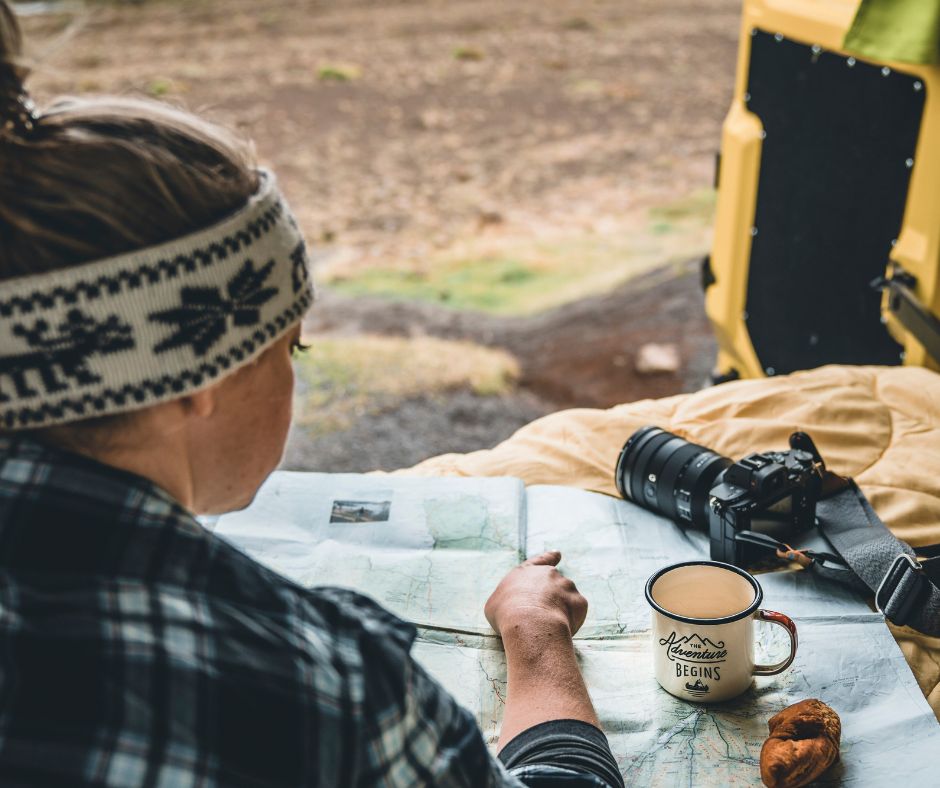 Picture of Jeannie from Iceland with a View Inside her Happy Campers Iceland Rental Campervan Planning her Trip with a Map. 