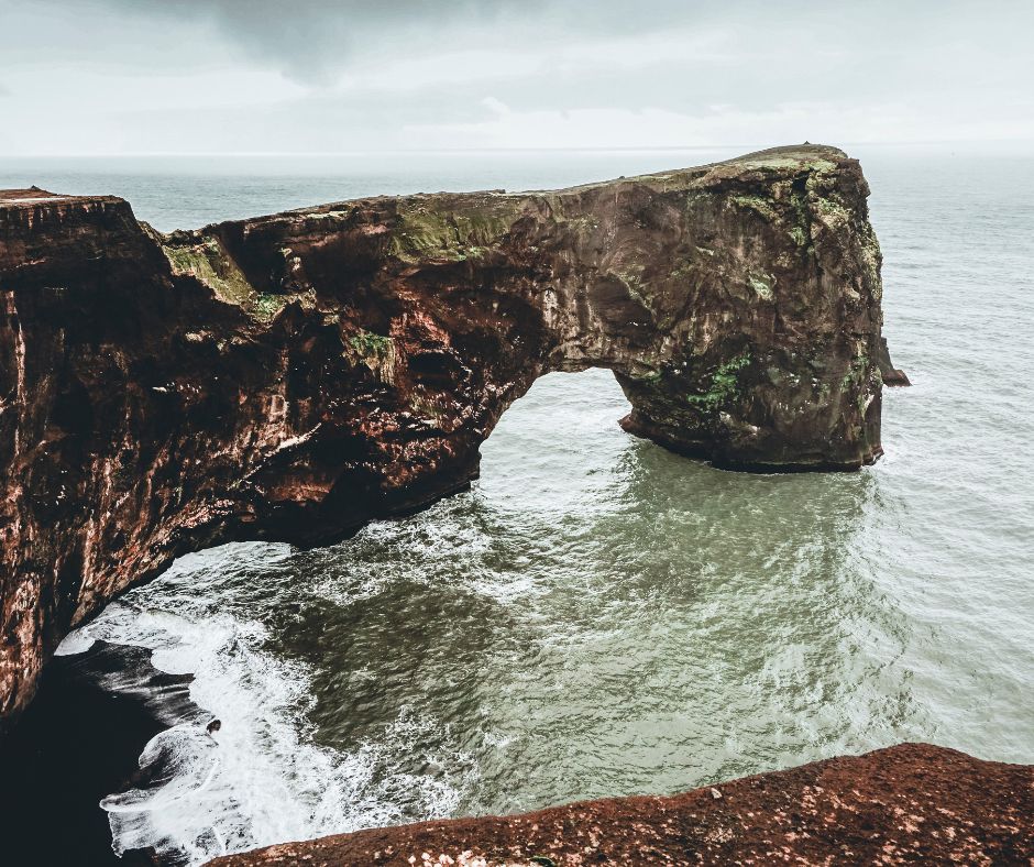 Picture of the Large Rock Arch that Sticks Out into the Ocean and is Home to a Large Puffin Colony in Iceland | Iceland with a View 