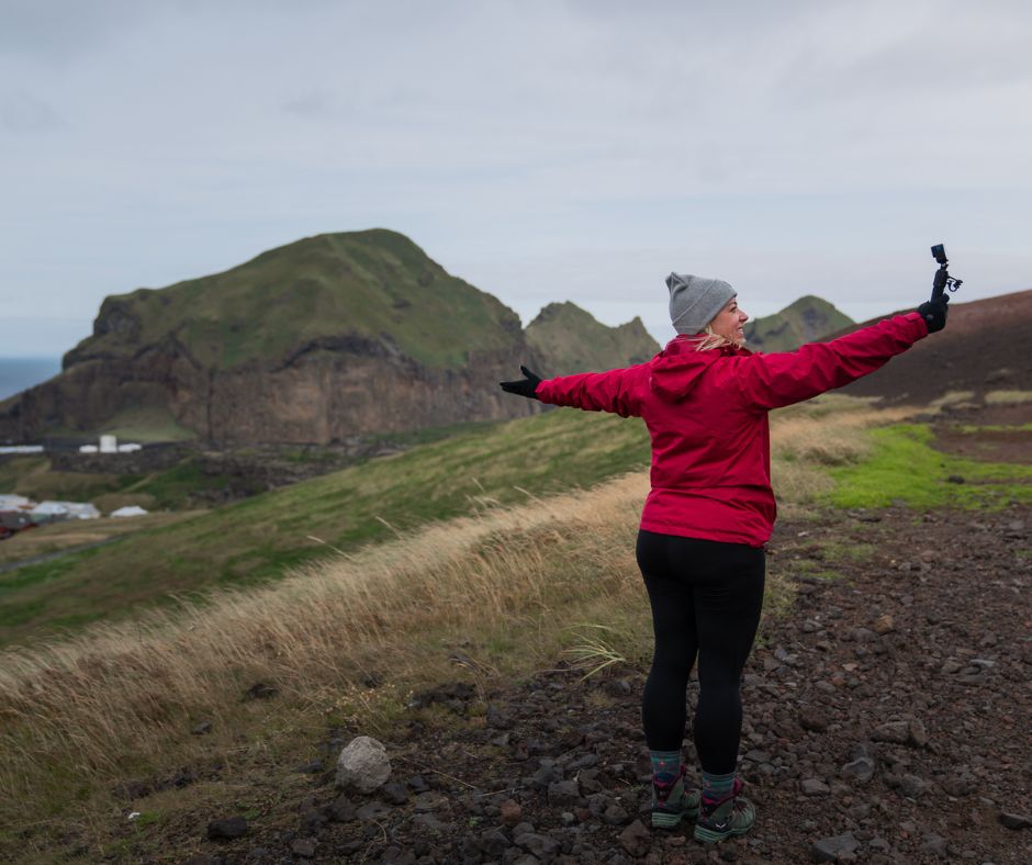 Picture of Jeannie Filming on Camera Wearing Rain Gear for Iceland | Iceland with a View 