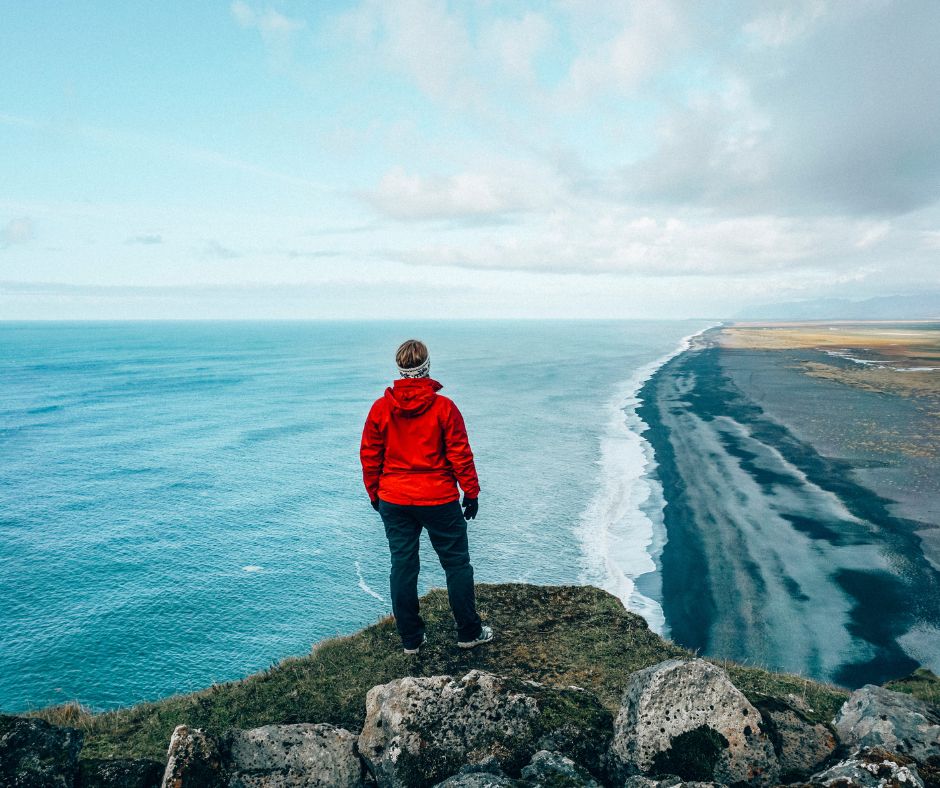 Picture of Jeannie Sightseeing Dyrholaey While Wearing Rain Gear for Iceland | Iceland with a View 