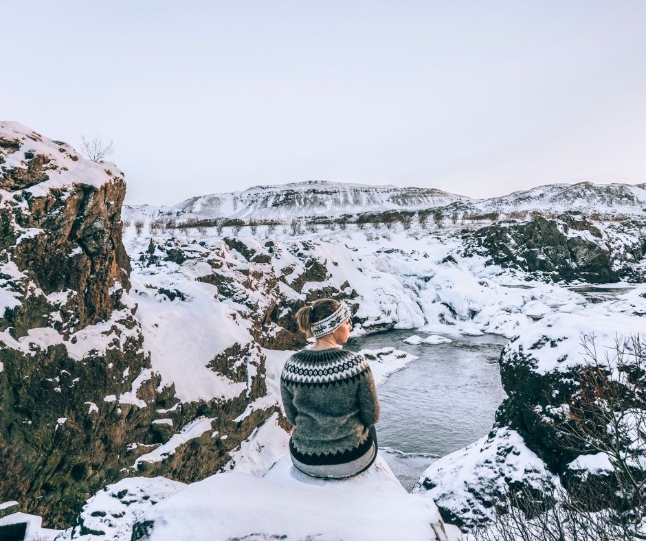 Jeannie Sitting on a Rock Admiring the Beauty of the Snow Setting in Every Rock in Iceland | Iceland Winter Packing List | Iceland with a View 