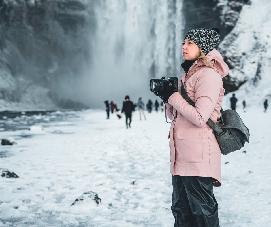 Picture of Jeannie Wearing a Waterproof Raincoat while Taking Pictures in Skogafoss during the Winter | Iceland Winter Packing Guide | Iceland with a View 