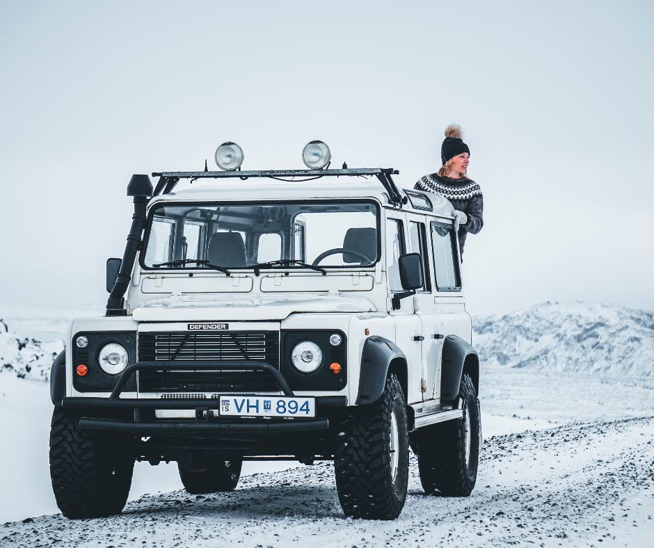 Picture of Jeannie Standing in the Back of Her 4-Wheel Drive Car while Posing for the Camera in the Middle of the Street in Iceland in Winter | Iceland with a View 