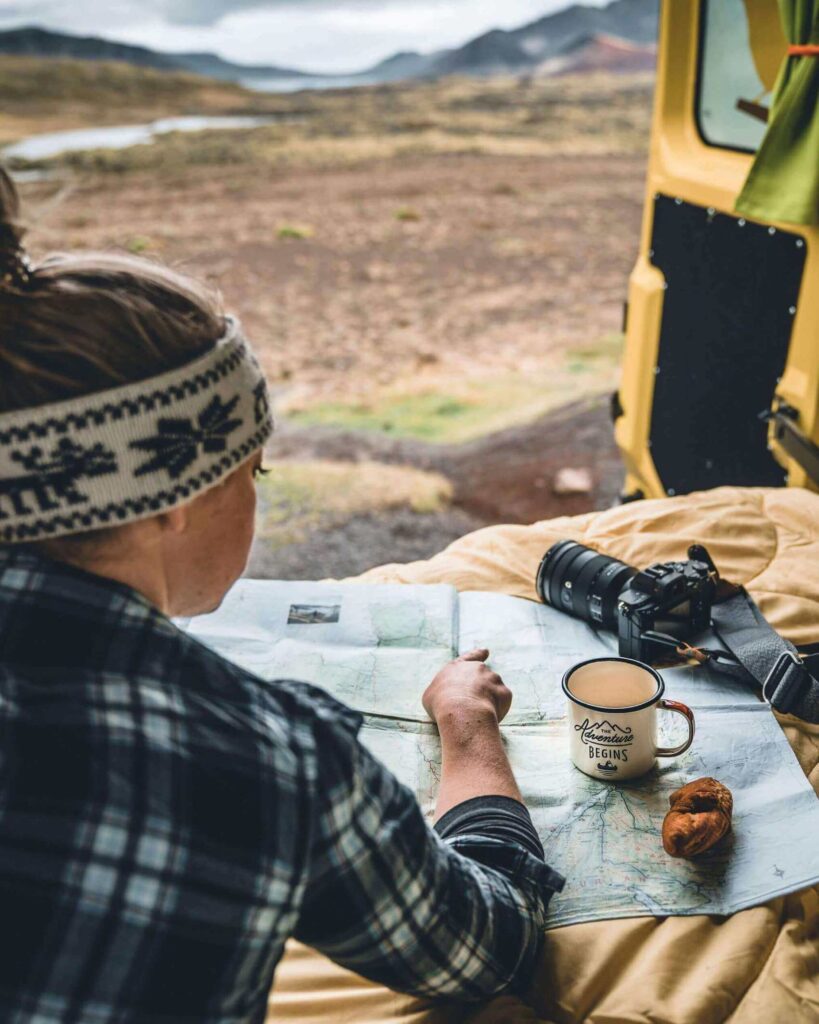 Picture of Jeannie Looking at the Iceland Map and Drinking Coffee Inside of Happy Camper's Van in Iceland | Iceland with a View 