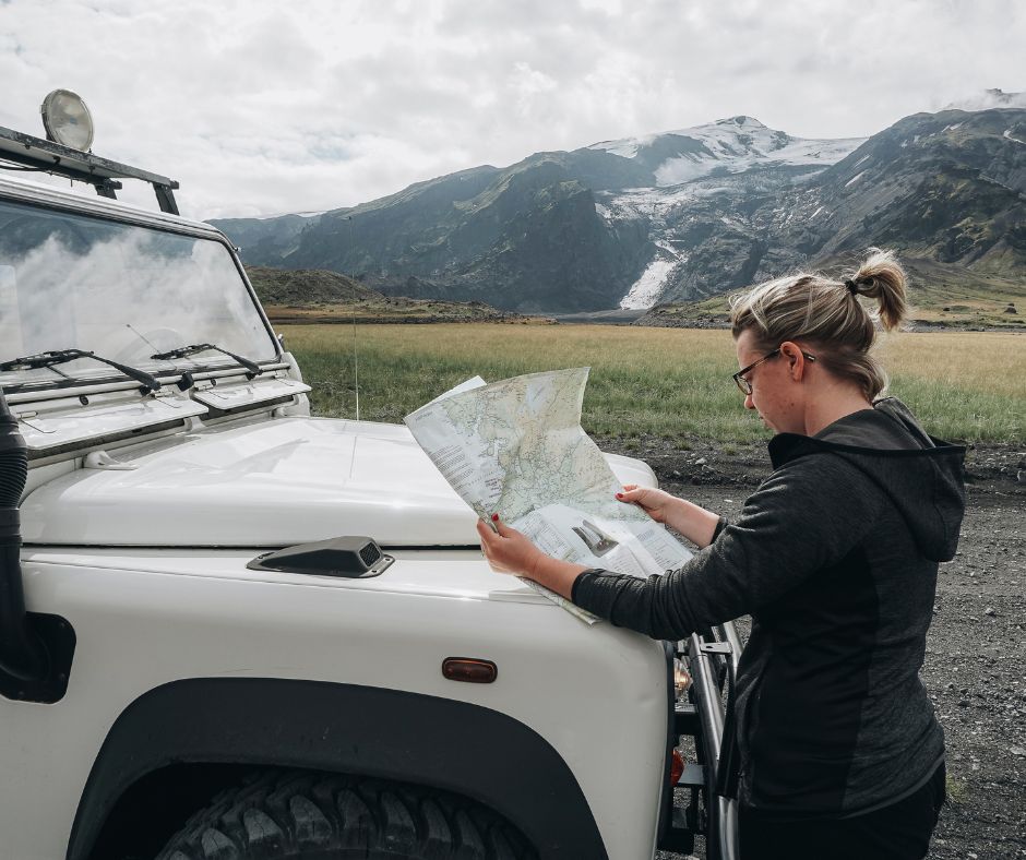 Picture of Jeannie Reading a Paper Map Near her Defender Truck in the F-roads in Iceland | Iceland with a View