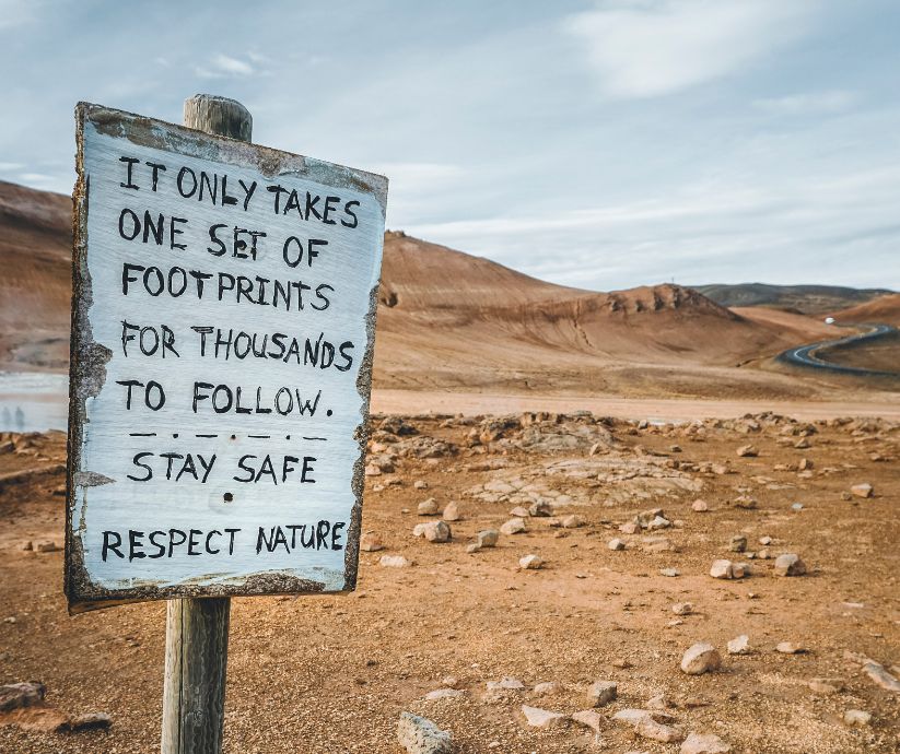 Picture of a Sign in Hverir, Mývatn that Says "It Only Takes One Set Of Footprints For Thousands To Follow. Stay Safe. Respect Nature." | Iceland with a View