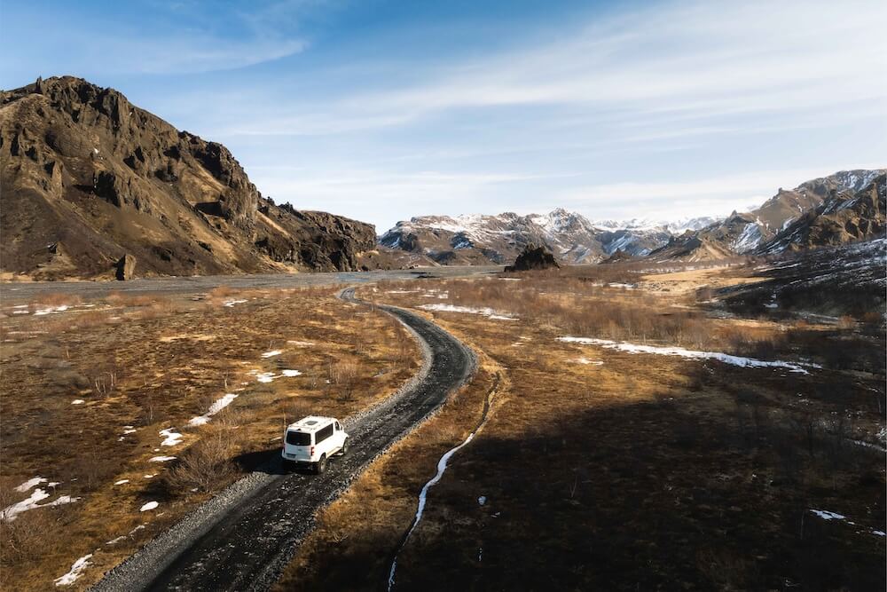 Landscape View of a Car Passing Through the Road of the Highlands | Campervan vs Car Rental | Iceland with a View 
